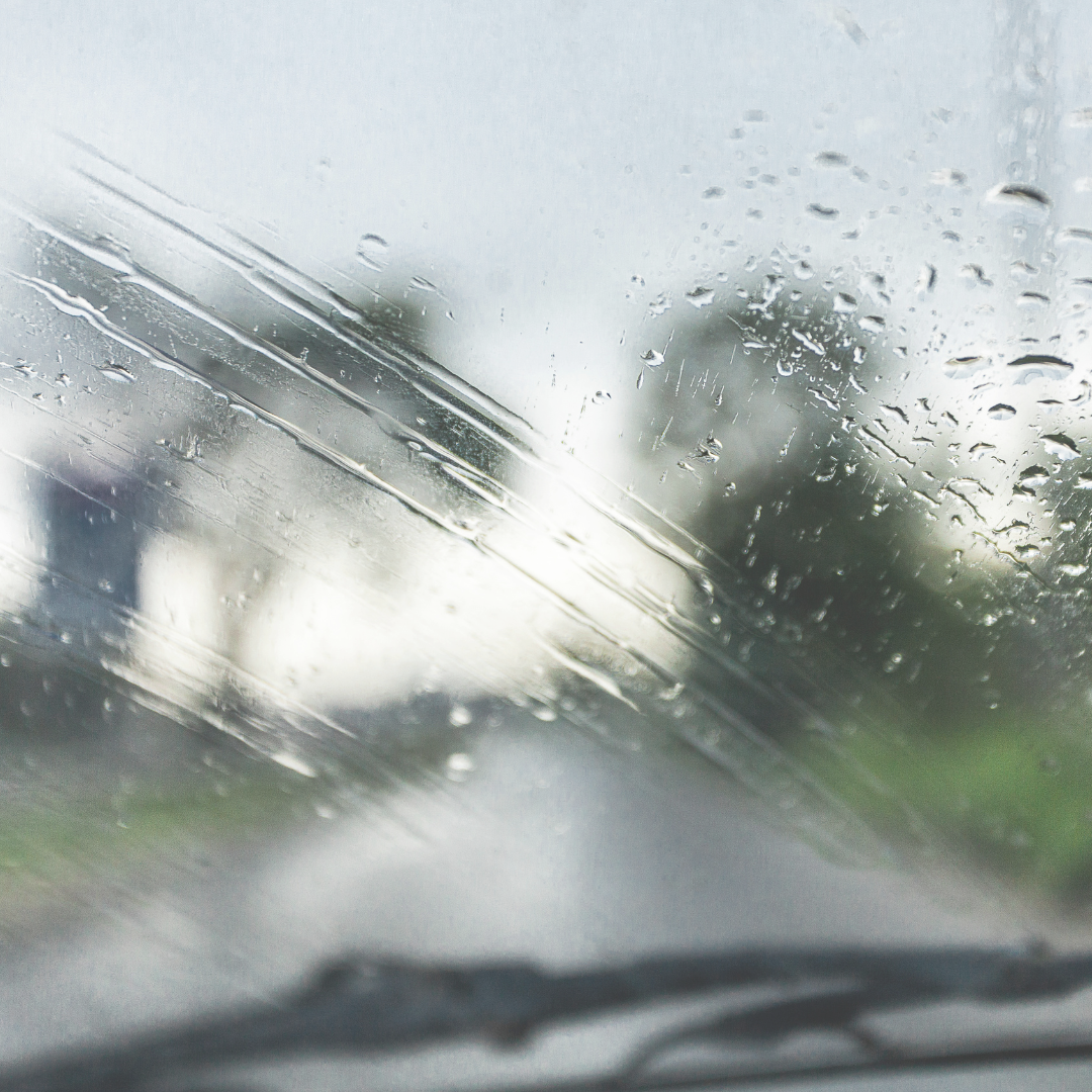 imagem de um vídor embaçado e com gotas de chuva em uma estrada.